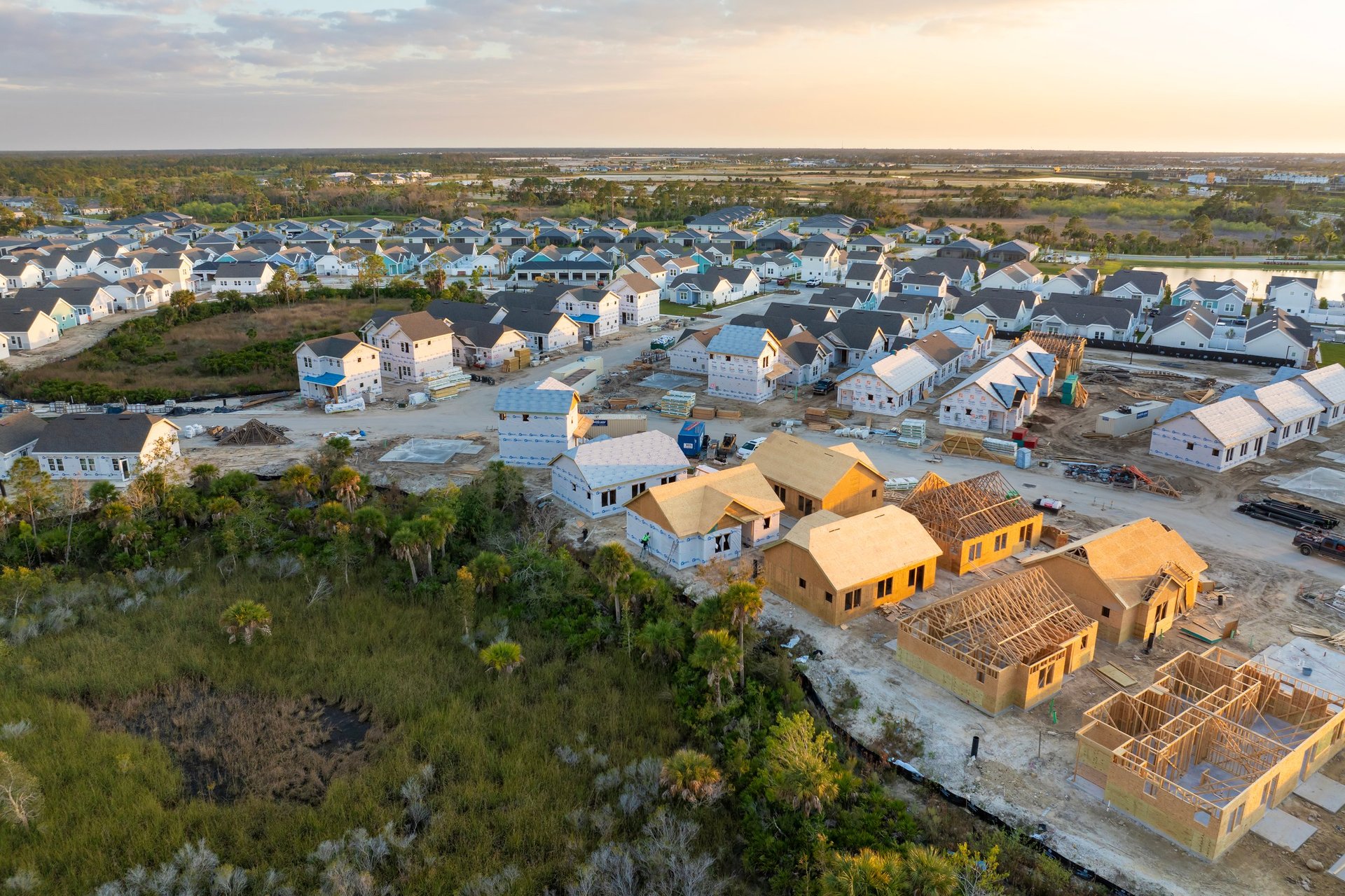 Wooden houses under construction in new developing suburban area. Development of residential housing in American suburbs.