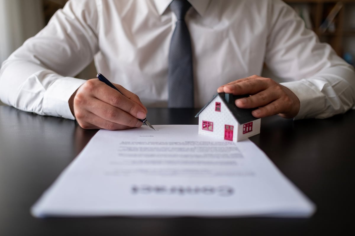 The red roof house is placed on the agent's contract. Contract contracts, signatures on documents, customer partners, customers who purchase products or contract contracts, home trading ideas.