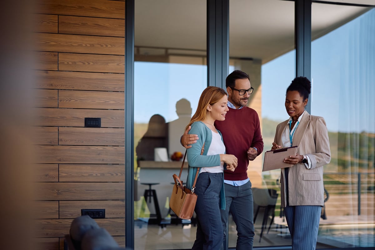 African American real estate agent going through housing plans with a couple who is buying a new home. Copy space.